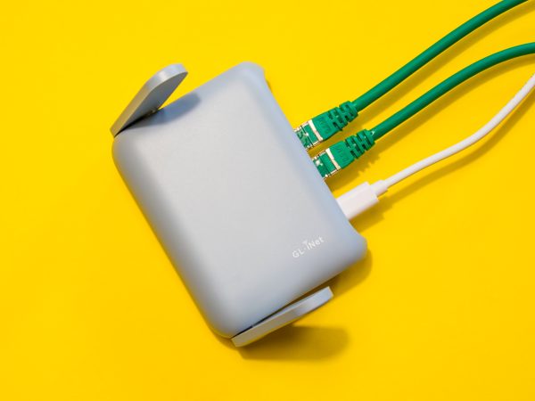 GL-iNet router op een gele achtergrond