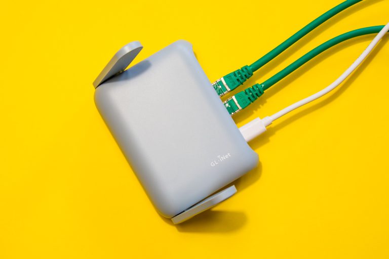 GL-iNet router op een gele achtergrond