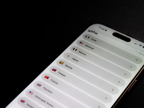 Smartphone met de Yoho eSIM app en een lijst van landen met vlaggen tegen een zwarte achtergrond