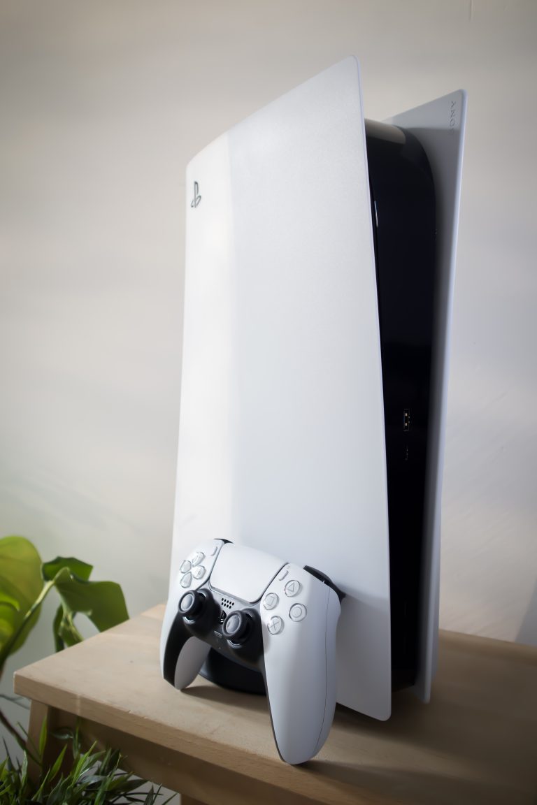 PlayStation 5 console rechtop op houten plank in woonkamer met een groene hint van een plant