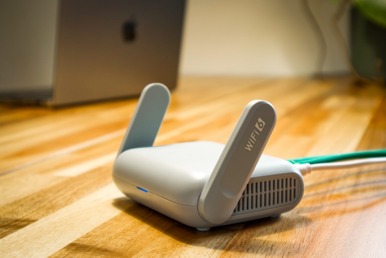 GL.iNet Beryl AX wifi 6 router met opgeklapte antennes op een houten bureau