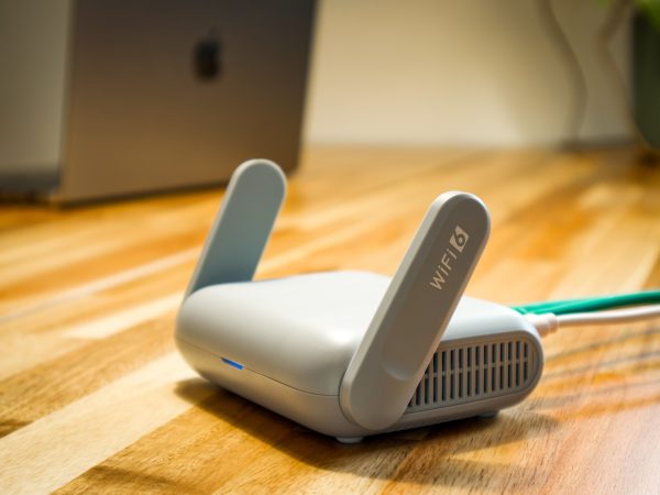 GL.iNet Beryl AX wifi 6 router met opgeklapte antennes op een houten bureau